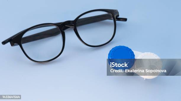 Glasses And Container For Contact Lenses On A Light Blue Background Stock Photo - Download Image Now
