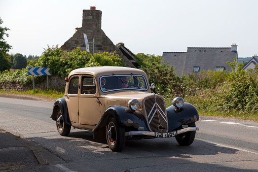 Kerlaz, France - July 17 2022: Retired couple cruising in a Citroen Traction Avant 7C.