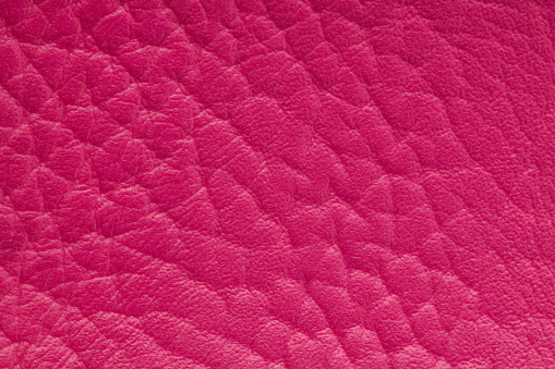 Pink artificial or synthetic leather background with neat texture and copy space, colorful fabric sample with leather-like finish aimed for upholstery, fashion, sewing or footwear projects