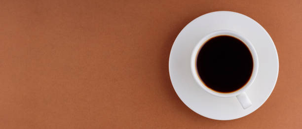 istock Cup with coffee on saucer on brown background. Black coffee for breakfast. Flat lay. Panoramic shot 1433649131