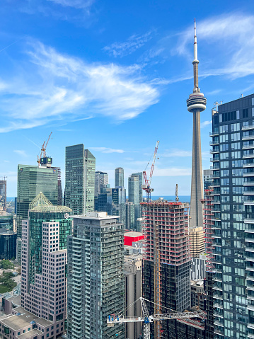 Toronto skyline in the day over lake with urban architecture and blue sky