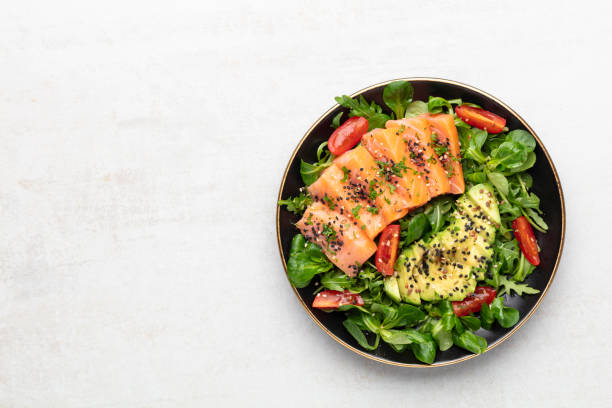istock Salmon fish fillet with fresh salad, avocado top view. 1433651314