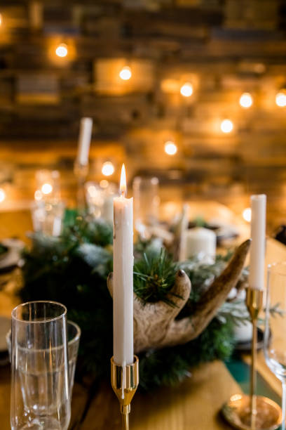 istock A decorated christmas dining table with wine glasses and christmas lights .Festive table setting among winter decorations and white candles. family dinner.New year candle ornament on wooden table 1433654053