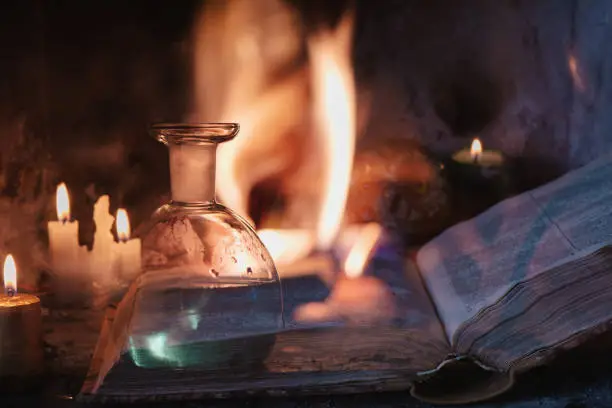 Magic potion, spell book, candles and fire