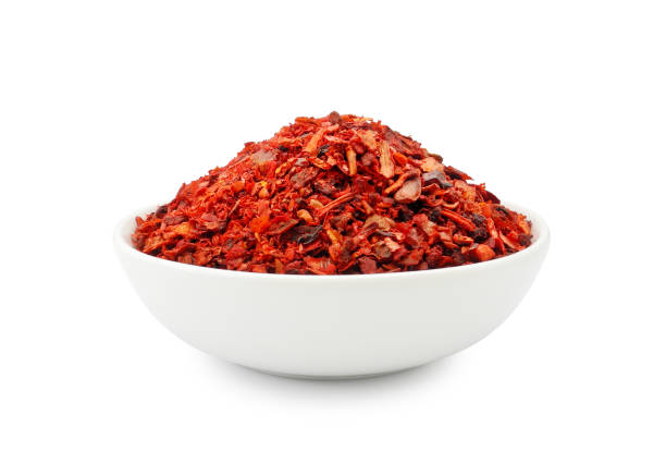 Paprika flakes in bowl isolated on white