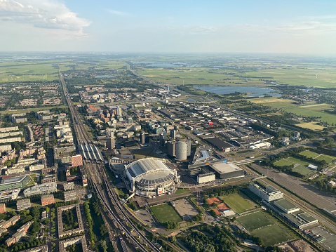 Aerial view over the city of Amsterdam and it's suburbs on the approach to Schiphol Airport in the Netherlands. The Ajax football stadium can be seen.