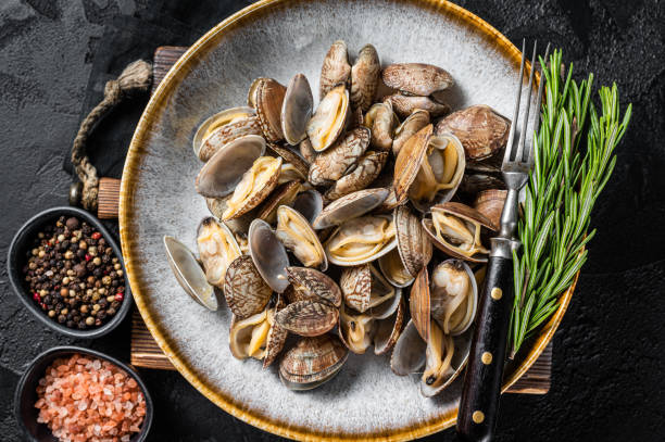 istock Steamed cooked shells Clams vongole in a plate with herbs. Black background. Top view 1433663175