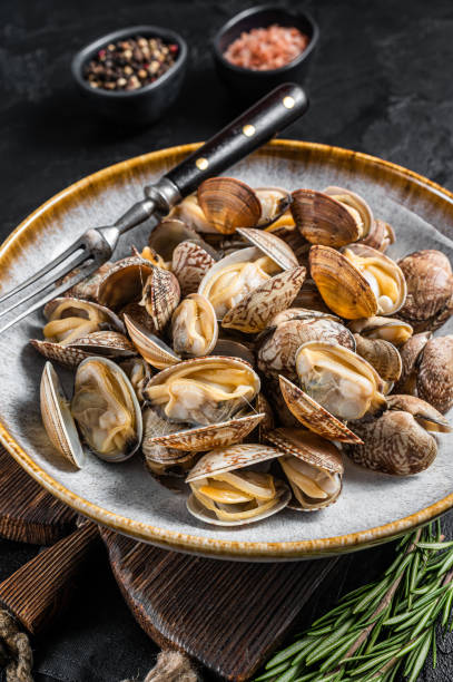 istock Steamed cooked shells Clams vongole in a plate with herbs. Black background. Top view 1433663217