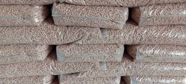 pellet di legno in sacchetti di plastica. carburante ecologico. pellet di legno impilati. - byproduct foto e immagini stock