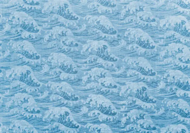Closeup detailed photograph of traditional Japanese wrapping cotton cloth named furoshiki depicting a pattern of a great wave in blue sea evocating the popular cresting wave of ukiyo-e artist hokusai.