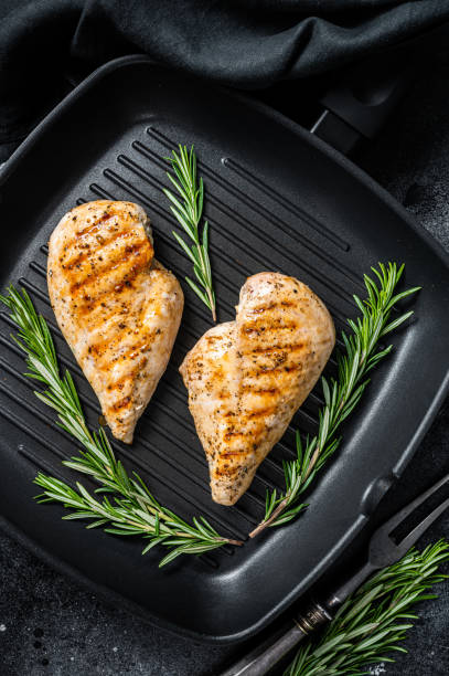 istock Grilled healthy chicken breasts cooked on a grill pan. Black background. Top view 1433668242