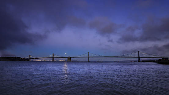 Images of the Bay bridge in San Francisco under a full moon