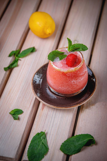 alkoholischer erfrischender gin tonic cocktail mit erdbeer-smoothie und minze mit eiswürfeln, auf der sommerterrasse des restaurants. erdbeer-daykiri - strawberry daiquiri stock-fotos und bilder
