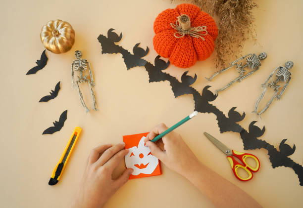 istock Step-by-step instructions for creating garlands of paper decorations by children for the Halloween holiday. Step 3 - draw a pumpkin figurine on the top layer 1433673756