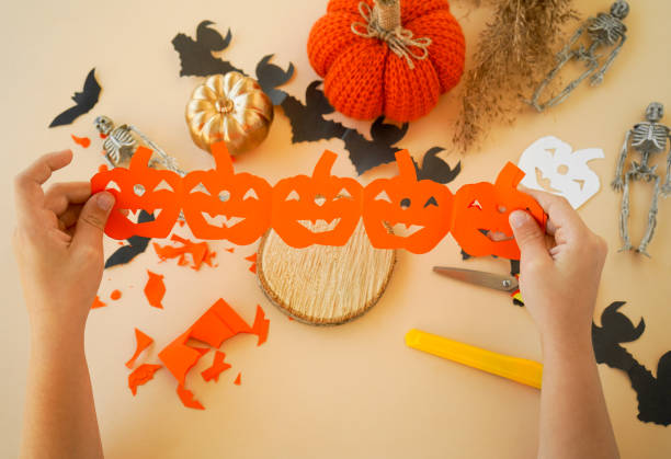 istock Step-by-step instructions for creating garlands of paper decorations by children for the Halloween holiday. Step 6 unfold the folded strip. 1433673784
