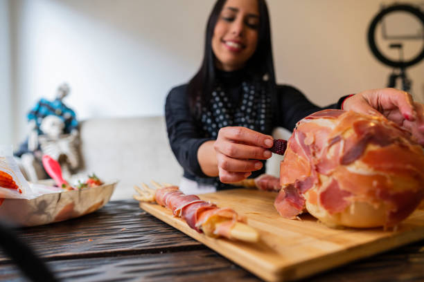 Female chef prepares a delicious cheese board for halloween using pumpkin skulls and delicious ingredients