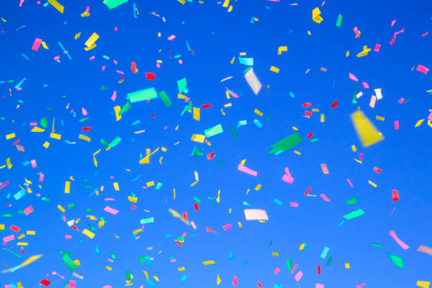 istock multicolored confetti on clear blue sky background. Concept of holiday backdrop 1433679287