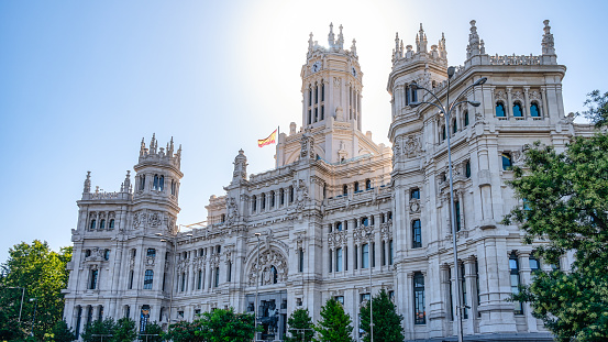 Madrid, Spain - September 25, 2022: Low-angle view of the facade of a palace.  The building has tower-like structures on its upper part, and no people are on the scene.
