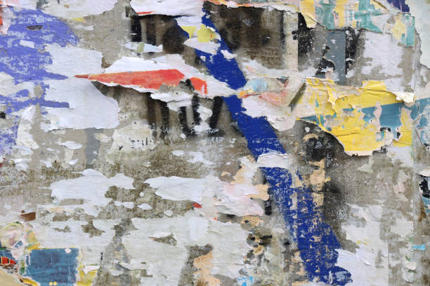 istock Pieces of torn paper peeling off wall used as billboard 1433683451