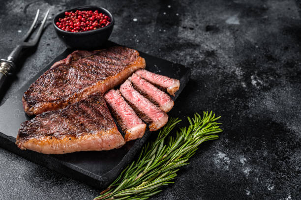 controfiletto superiore alla griglia o bistecca di carne di manzo alla tazza su tavola di marmo. sfondo nero. vista dall'alto. spazio di copia - picanha beef meat rare foto e immagini stock