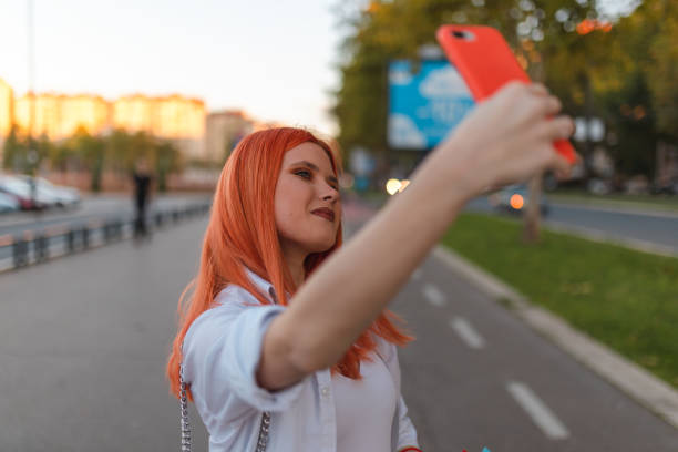 istock Beautiful young redheaded woman taking a selfie while out shopping 1433686222