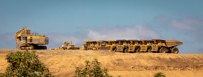 Large dump trucks with an excavator at a construction site