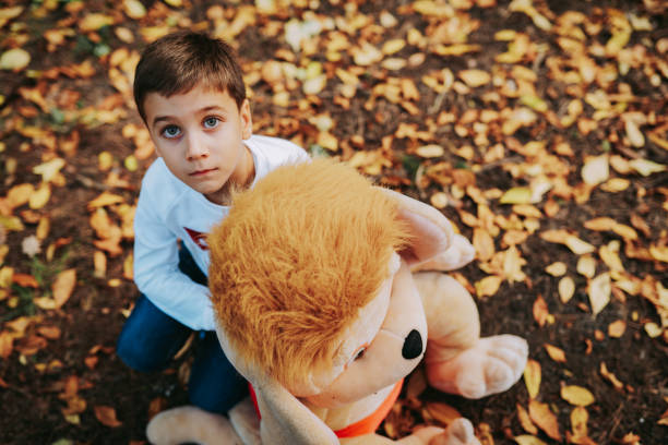 A boy and his bear are enjoying themselves in the park