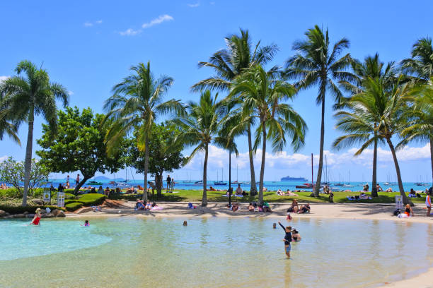 Airlie Beach, Qld - Oct 02 2022:Tourists enjoying Airlie Beach Lagoon a free swimming pool loaded with self chlorinated water on the foreshore of Airlie Beach in Queensland, Australia.