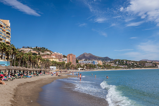 Malaga, Spain - September 29, 2022: People enjoy a sunny afternoon at the beach in Malaga, Spain.