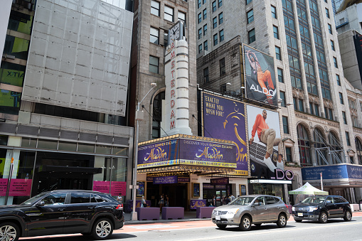 Chicago, IL, USA - June 6, 2023: People stand under the iconic Chicago Theater marquee and sign at dusk.