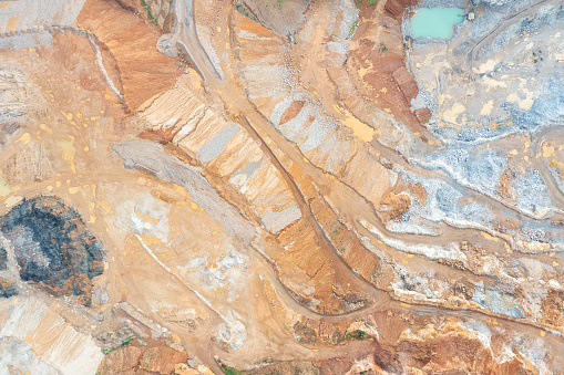 Aerial view of the quarry, beautiful orange patterns and overhanging rocks in a copper-magnesium quarry