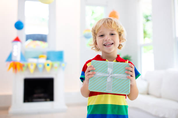 istock Space theme kids birthday party. Boy with present. 1433698520