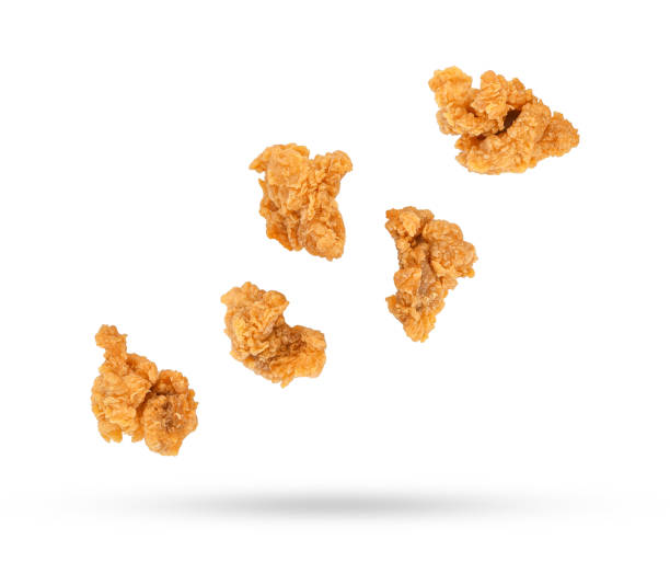 istock Fried popcorn chicken falling in the air isolated on white 1433708302