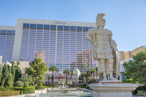 Las Vegas, NV - November 24, 2021: Closeup of the statue of Caesar at Caesar's Palace, with the Flamingo Hotel Casino beyond, on Las Vegas Boulevard.