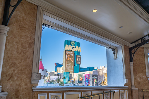 Las Vegas, NV - November 24, 2021: The beautiful MGM Grand Hotel and Casino visible in the distance, framed by an opening in an outdoor pedestrian walkway over Las Vegas Boulevard.
