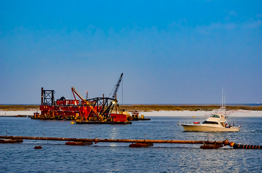 Sportfish boat passing the dredge in Perdido Pass, Orange Beach, Alabama