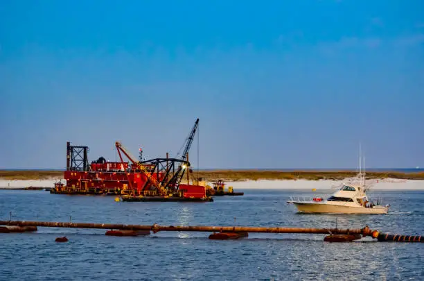 Sportfish boat passing the dredge in Perdido Pass, Orange Beach, Alabama