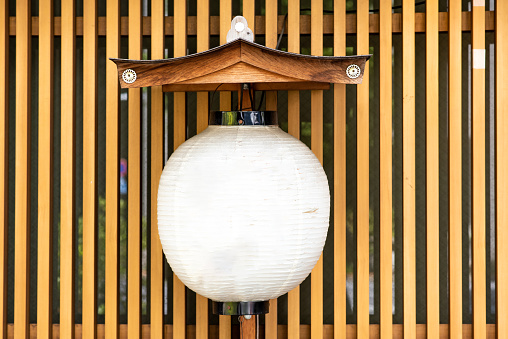 A beautiful paper lantern against a bamboo fence in Japan. Mock up with space for lettering or text.