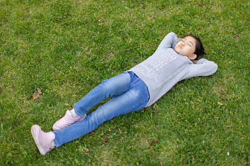 Little Girl Lying on Back the Grass