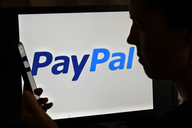 :Silhouette of upset Australian woman over PayPal logo stock photo