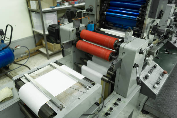 istock Paper web feeding and alignment unit in a roll rotary flexographic printing machine. Equipment for printing house. Selective focus 1433745961