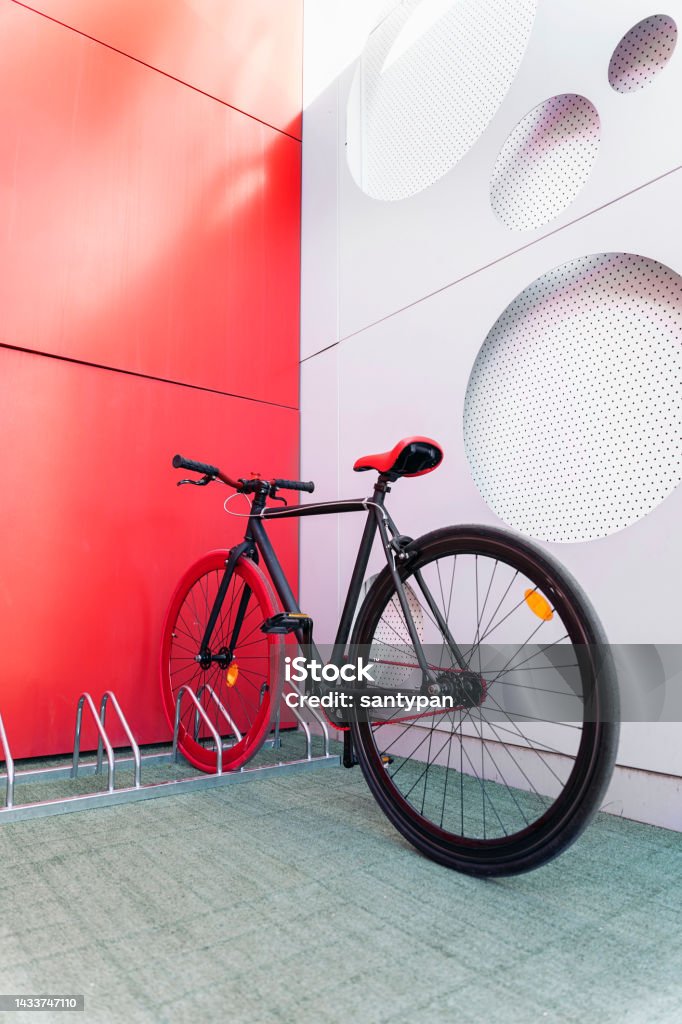 Cool Bike Parked in the City Beautiful red bike parked in the city in a special parking for bicycles. Bicycle Parking Station Stock Photo