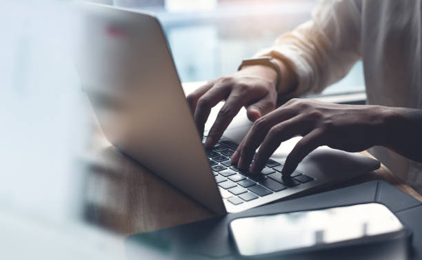 istock Business man working on laptop computer, typing on laptop keyboard on office table, surfing the internet, online job, online study, e-learning, working at home, telecommuting concept 1433751522