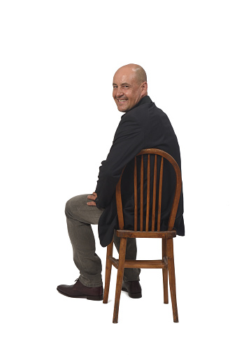 man sitting on chair and looking at camera on white background