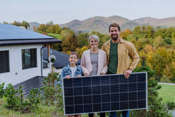 istock Happy family near their house with solar panel. Alternative energy, saving resources and sustainable lifestyle concept. 1433753338