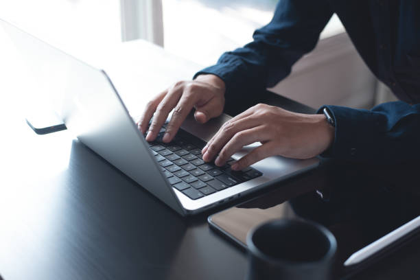 istock Business man hands typing on laptop computer keyboard, searching information, surfing the internet on dark office desk, distance job, online working, business and technology concept 1433754920
