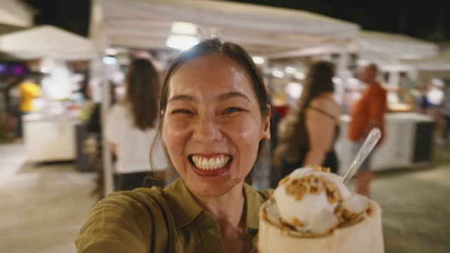 Young Asian influencer with fruit juice spinning around with camera