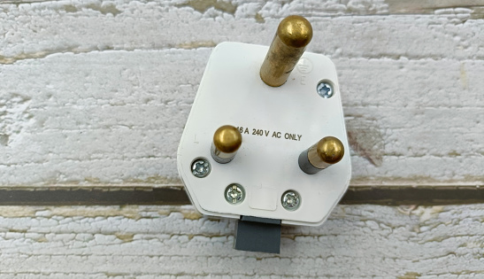 3 pin power plug on wooden background