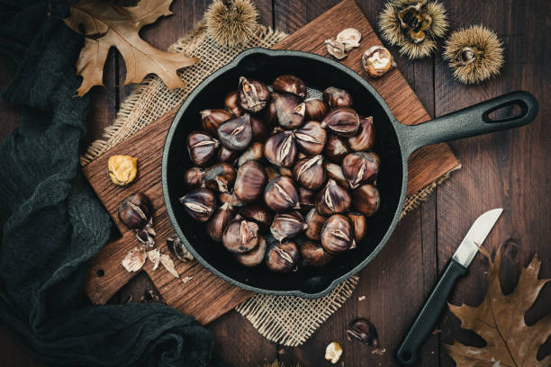 istock Roasted chestnuts in a cast iron pan on a wooden board 1433765525
