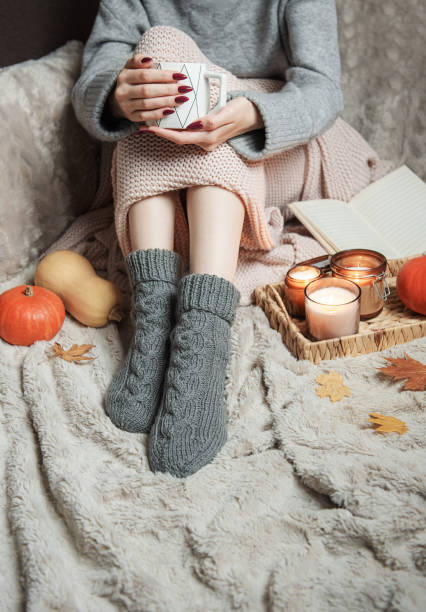 istock Cozy home, woman covered with warm blanket, drinks coffee. 1433770319